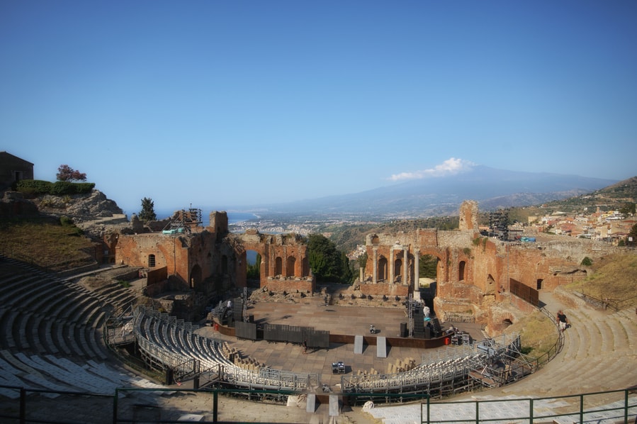 The Etna volcano in the background at the Teatro Antico in Taormina in one day Sicily Italy