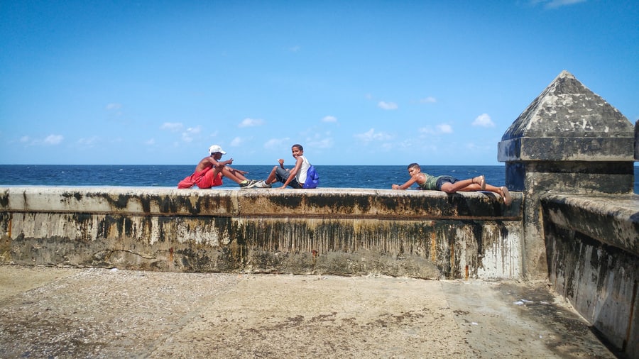 Niños disfrutando de las olas en el Malecón de la Habana cuba
