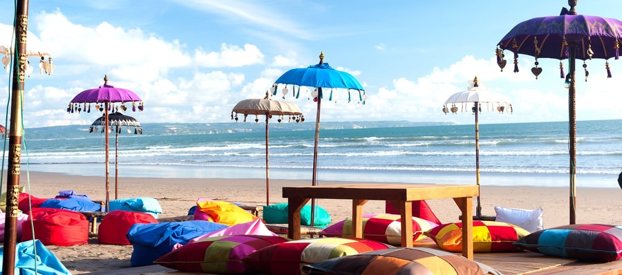 playa sombrillas de colores en kuta, una de las mejores zonas para alojarse en Bali
