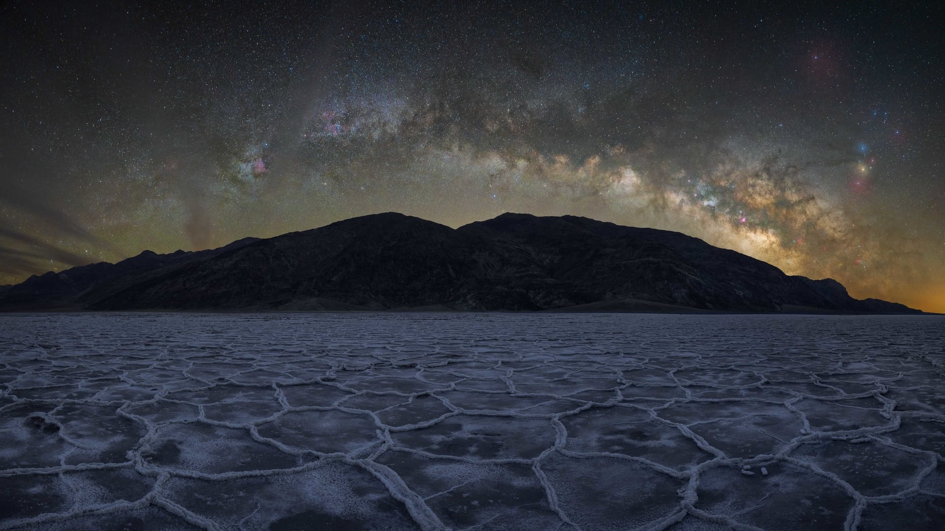 Milky Way arch over mountain and dry land in Death Valley