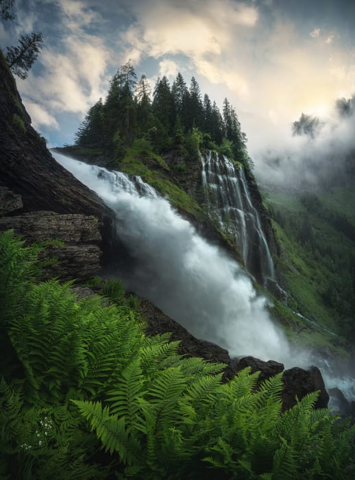 Tall waterfall with a layer of ferns in the foreground