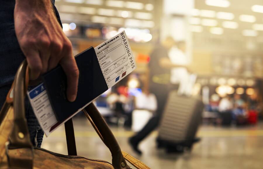 Traveler with boarding pass, best cheap travel insurance