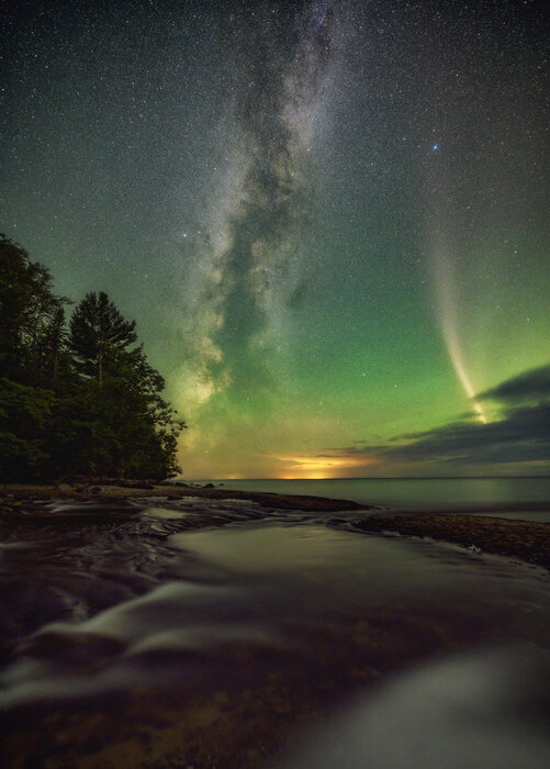 Northern lights and the milky way shining bright over a lake in Michigan