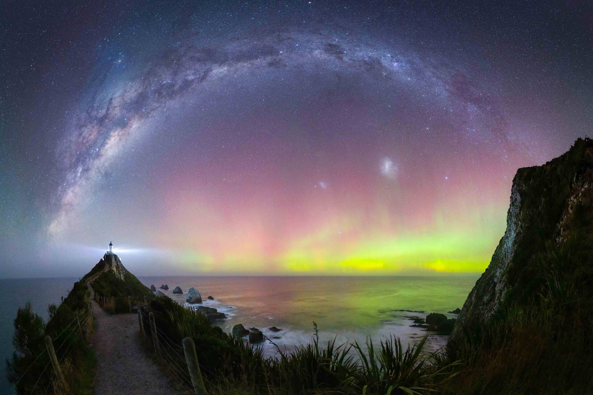 Full Milky Way arc covering the sky and shining over a bright Aurora Australis