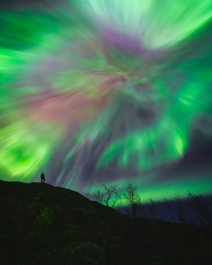 Brillante Aurora cubre por completo el cielo nocturno sobre un espectador