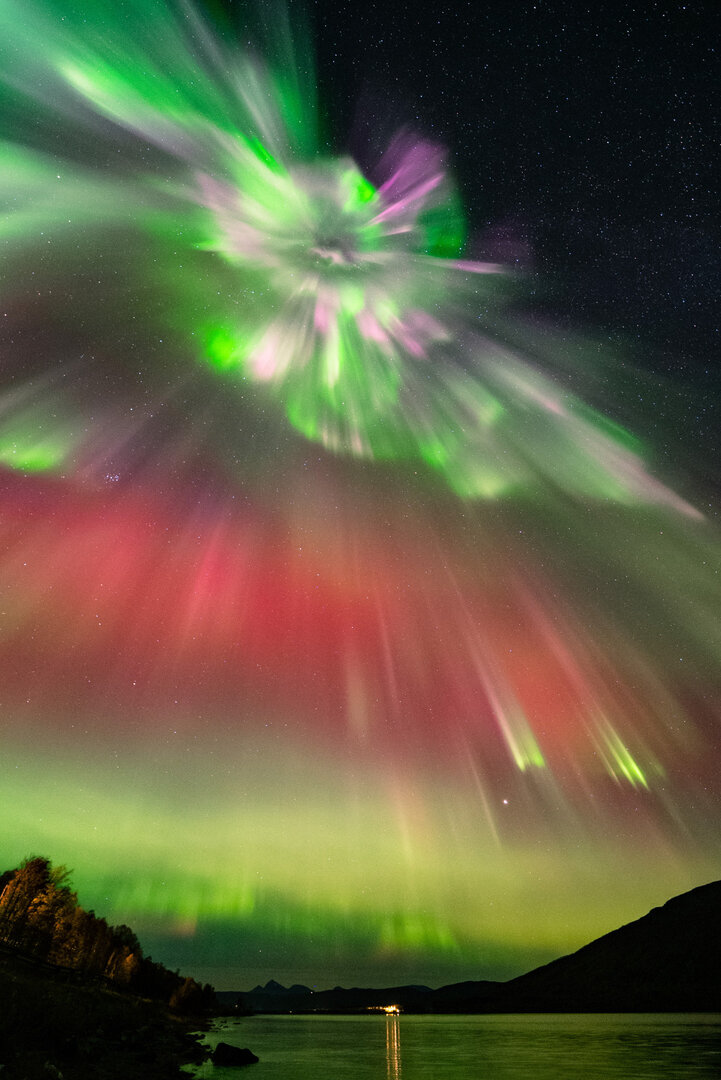 Una corona de Aurora cubre el cielo con brillantes colores verdes, magentas y rojos