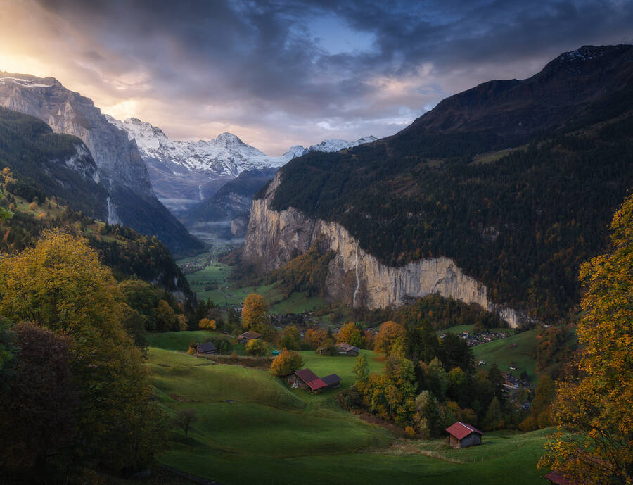 Lauterbrunnen valley covered in green grass and fall colors and lit by the golden sunset light