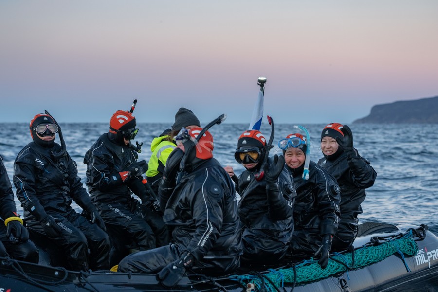 A group of divers in drysuits