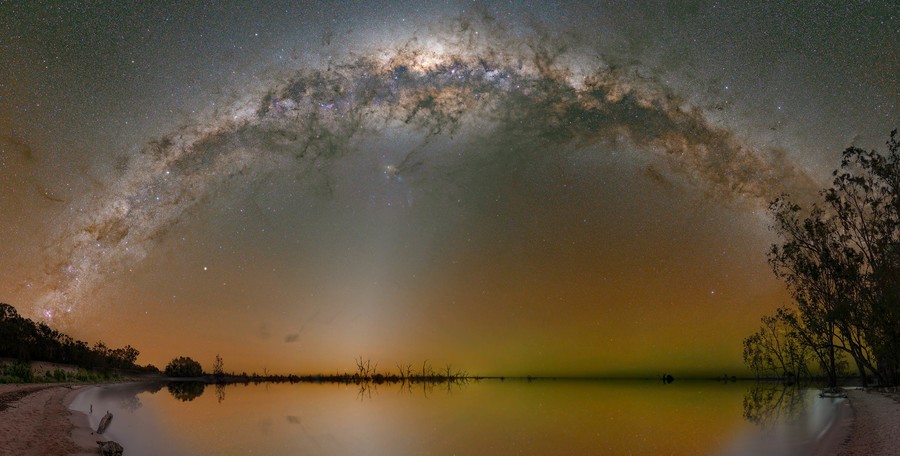 Milky Way arch over the Menindee lakes with some trees in the foreground