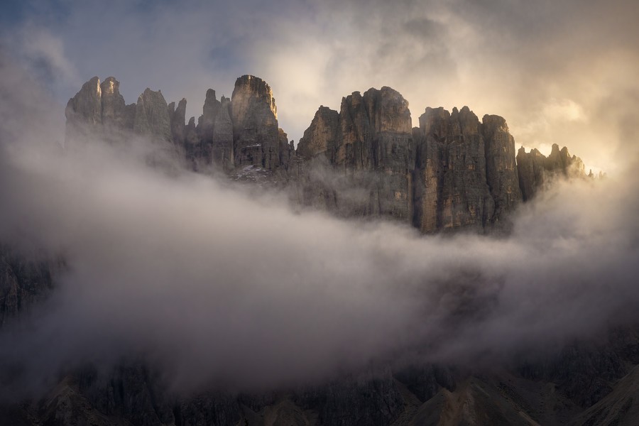 Dramatic peaks of Lago Carezza covered in clouds and soft light