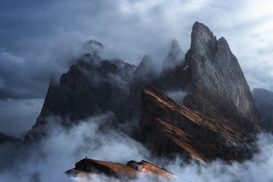 Telephoto shot of Seceda peaks during a cloudy and foggy morning in the Dolomites