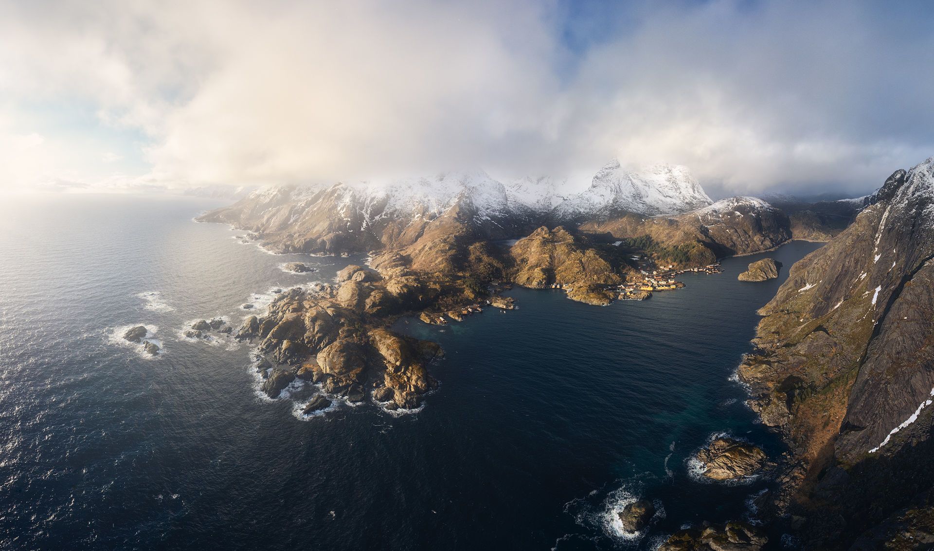 Aerial view of Nusfjord with dramatic lighting and clouds