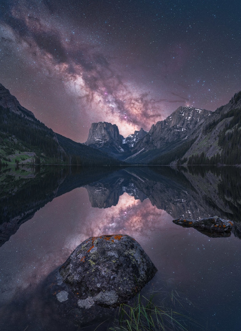 Vía Láctea cubre el cielo sobre un lago y unas montañas