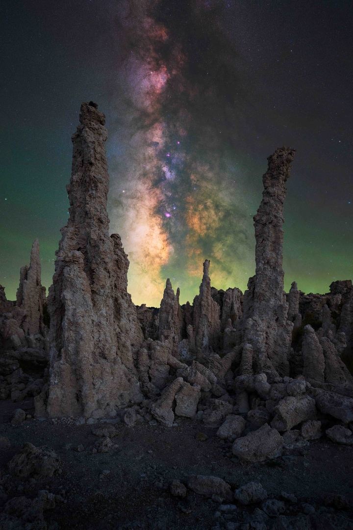 Vía Láctea en vertical cubriendo el cielo sobre unas formaciones rocosas en California
