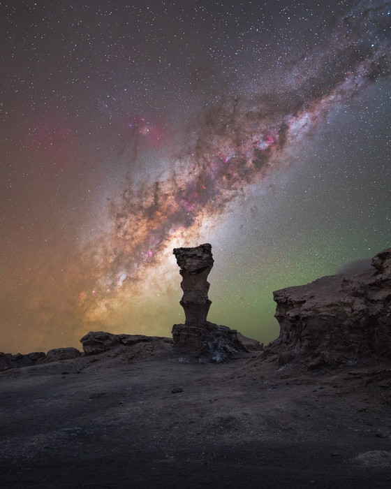 rock formation standing tall in the middle of the night with a starry sky filled by the Milky Way
