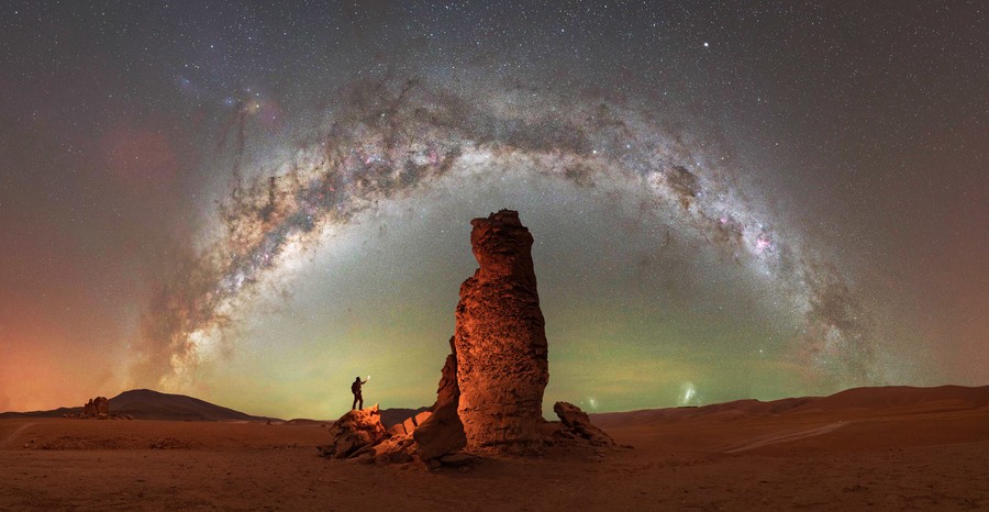 Rock formation under a Milky Way arch in the starry night sky