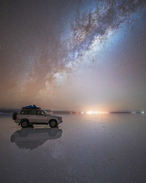 SUV under the night sky in Salar de Uyuni with the Milky Way