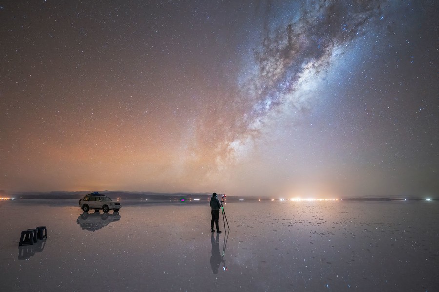 Person standing in the middle of salar de uyuni under the night sky with the milky way Milky Way in Salar de Uyuni