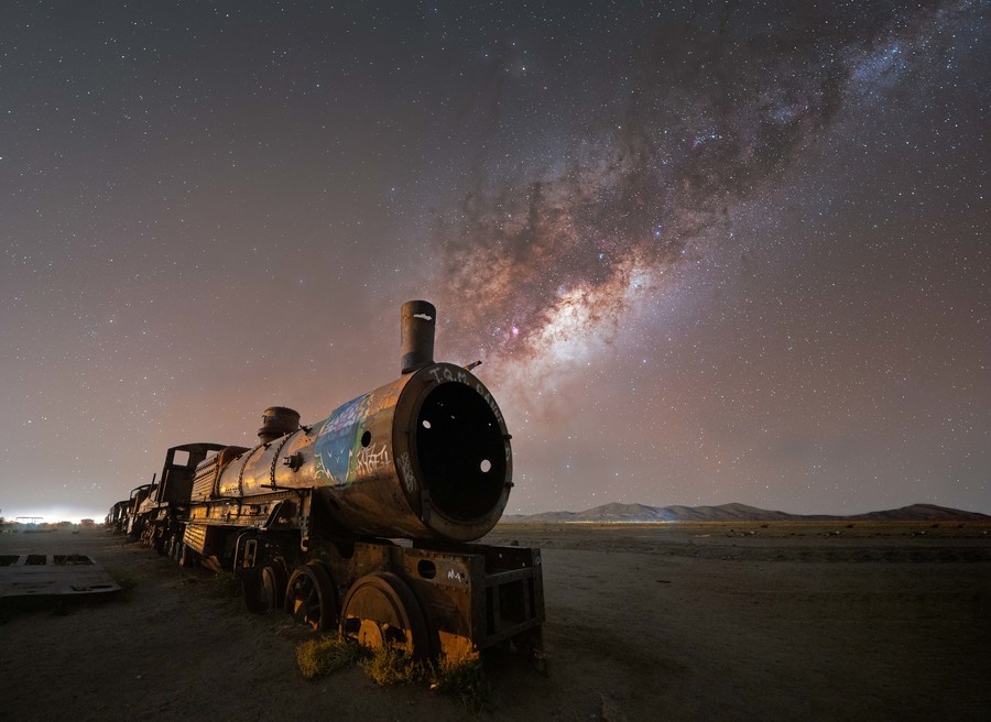Train under the night sky filled with the Milky Way