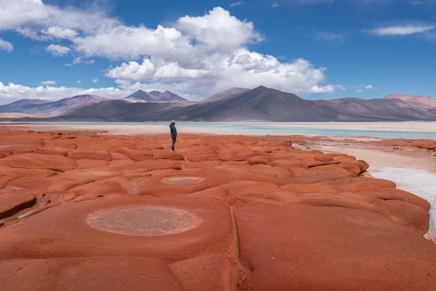 Person standing on rock formations in Salar de Aguas calientes