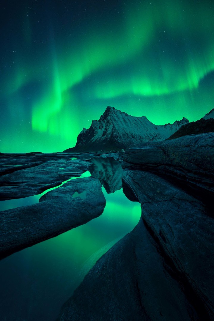Aurora Boreal se refleja sobre un pequeño charco en Lofoten, Noruega