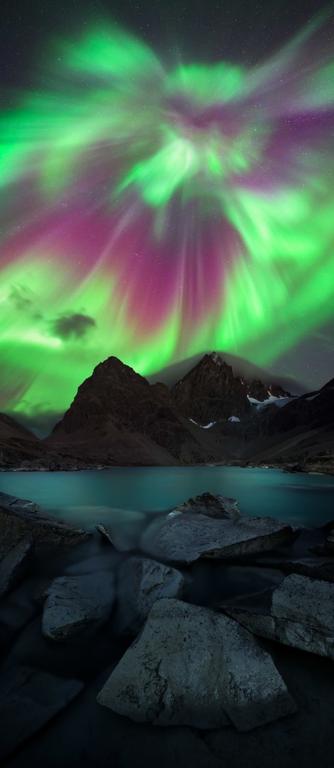 Aurora Boreal cubriendo el cielo casi por completo sobre una montaña en Noruega
