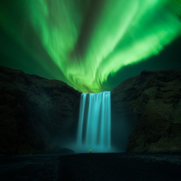 Aurora boreal sobre una cascada de Islandia