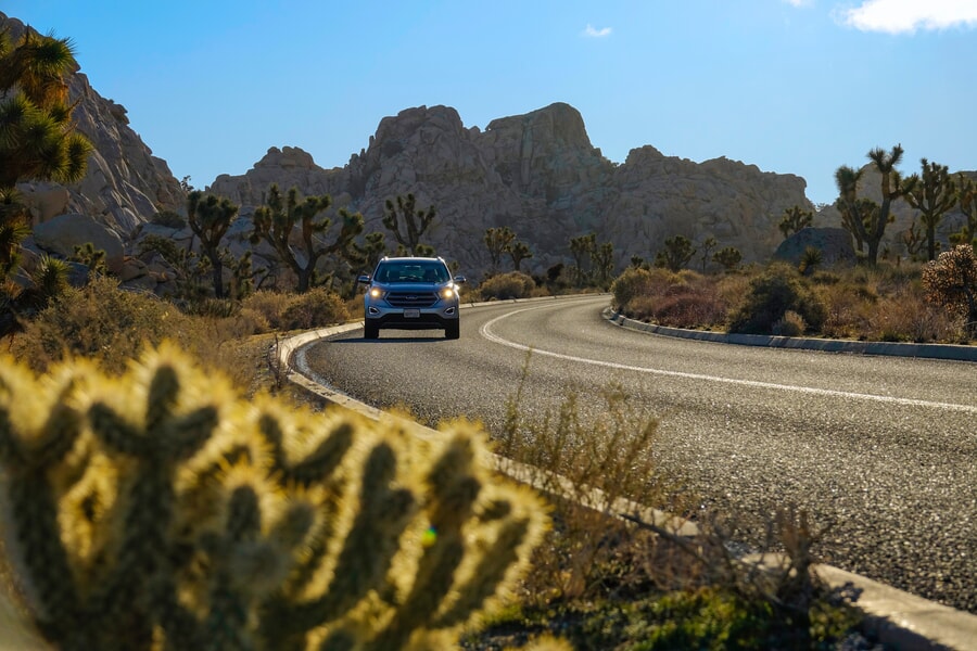 A panoramic landscape of Joshua Tree National Park, California, featuring distinctive rock formations and desert vegetation