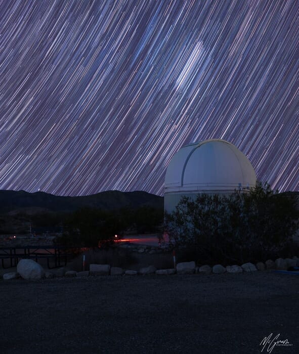 Star trails swirl above a desert observatory, Joshua Tree National Park