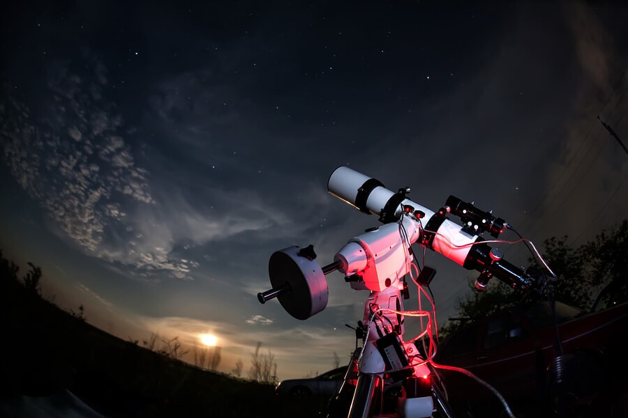 Big white telescope positioned on a hill under a starry night sky in Joshua Tree National Park