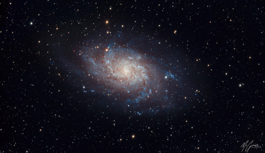view of a spiral galaxy, swirling arms and bright core against a dark background, deep sky