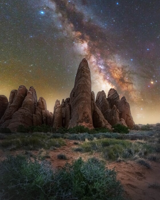The Milky Way shines over dramatic arches and rocky terrain in Utah workshop