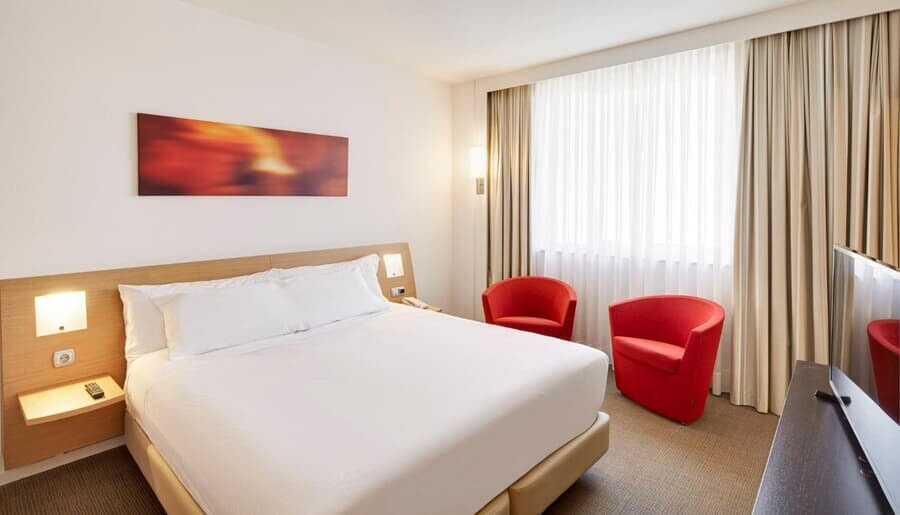 double bed and two red armchairs