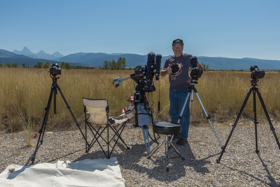 Fotógrafo listo para capturar un eclipse solar total con cámaras y telescopio.